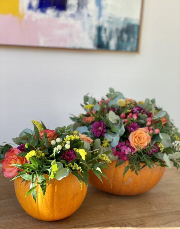 Two Pumpkins with flowers potted in the crown